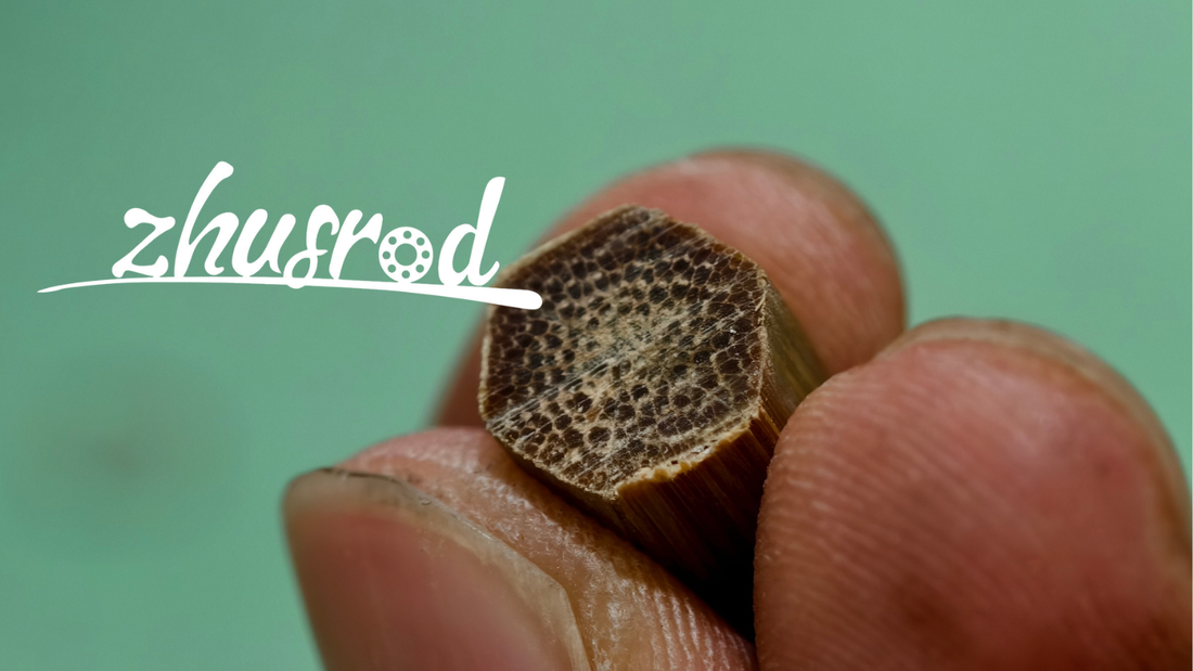 Close-up of a hexagonal bamboo rod cross-section held between two fingers.